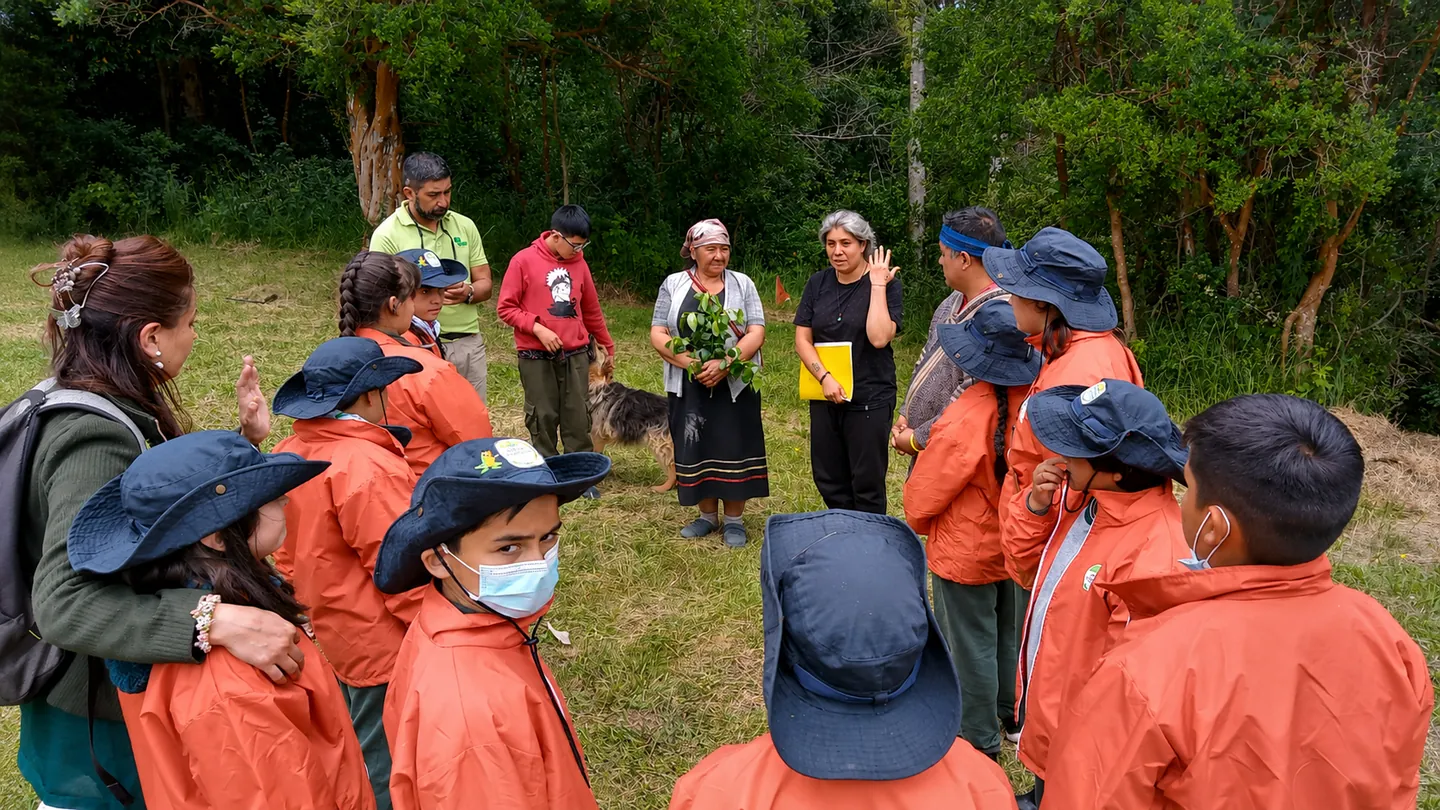 Grupo de jóvenes y personas adultas reunido al aire libre durante una actividad comunitaria